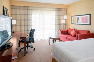 内珀维尔芝加哥内珀维尔万怡酒店的酒店客房,配有一张床和一张红色的沙发