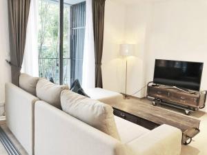 Ban Huai Sok NoiThe Valley byJT的客厅配有白色沙发和平面电视。
