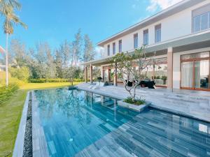 岘港Luxury Dana Beach Resort & Spa的房屋前游泳池的图像