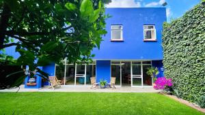 墨西哥城Casa Tamayo的蓝色的房子,配有椅子和庭院