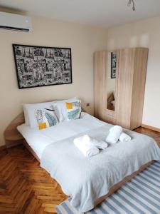 大特尔诺沃Apartment Zdravets的卧室配有带毛巾的大型白色床