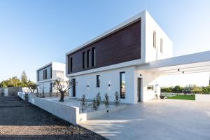 普罗塔拉斯Tsiolakki Homes Luxury Villas的黑色屋顶的白色房子
