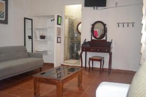 特科卢特拉Posada Casa Antigua的客厅配有镜子和钢琴