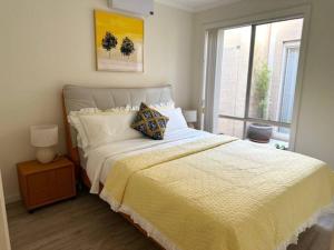 HarrisonTownhouse in Franklin的一间卧室配有一张带黄色毯子和窗户的床