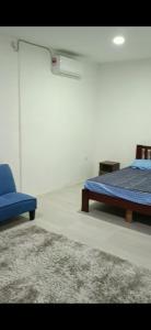 怡保Lanai Meranti的一间卧室配有两张床和一张蓝色椅子