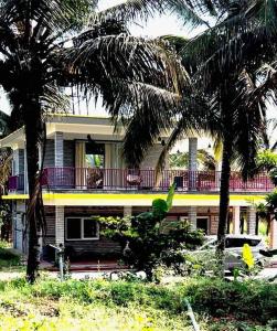 ChannarāyapatnaKashi Farm House的前面有棕榈树的房子