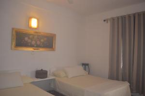特科卢特拉Posada Casa Antigua的一间设有两张床的客房,墙上挂着一张照片