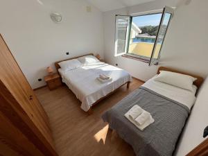 伊穆尼Beachfront Lovro apartment的一间卧室设有两张床和窗户。