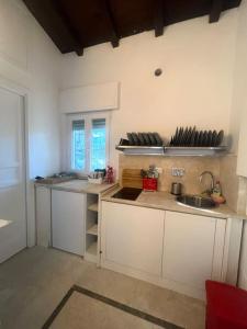 罗马Residenza Morlupo (Fleming)的厨房配有白色橱柜和水槽