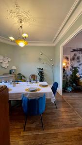德拉韦伊luxury Villa Marie Emeraude Paris Orly Jacuzzi的一间配备有白色桌子和蓝色椅子的用餐室