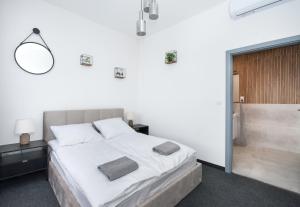 格利维采Apartamenty Zabrska 45的一间白色卧室,配有一张床和浴缸