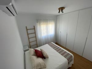 埃尔卡沃德加塔Tu casa en El Cabo的白色卧室配有红色枕头的床