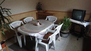 耶塞尼克Ranch Eden, Jeseník的餐桌、白色椅子和电视