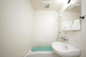 福冈goom Hotel Fukuoka-Kokusai-Center的浴室配有盥洗盆和浴缸。