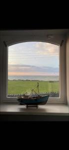 斯凯里斯Seaview Terrace的窗边的窗户,窗边有小船坐在窗边