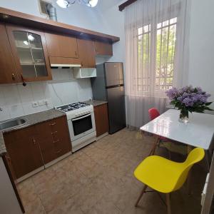 埃里温Family home的一个带桌子和黄色椅子的小厨房