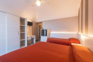 阿拉西奥Hotel Danio Lungomare的酒店客房设有两张床和电视。