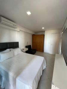 福塔莱萨Landscape Beira Mar Fortaleza的卧室配有一张白色大床和一把椅子