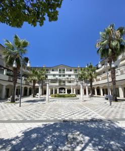 马里纳迪马萨Orange Apartment的一座棕榈树环绕的大建筑