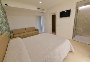 GonnosfanàdigaL'OLEANDRO Room's - Suite & Spa da Giuseppe的卧室配有白色的床和沙发