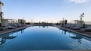 迪拜STAY BY LATINEM Luxury 1BR Holiday Home CVR A2803 near Burj Khalifa的大楼内带躺椅的大型游泳池