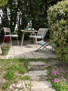 穆斯捷-圣玛丽阿特利耶苏蕾住宿加早餐旅馆的庭院配有两把椅子和一张桌子,种有鲜花