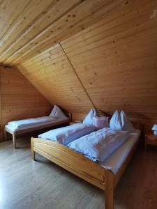 日亚尔Drevenica Západné Tatry的配有木天花板的客房内的两张床
