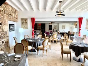 图尔农－圣马丹Hotel The Originals Le Manoir de Pierre Levée的一间在房间内配有桌椅的餐厅