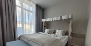 埃姆登法德普特酒店的一间卧室设有一张大床和大窗户