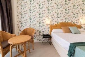 拉皮内达帕拉斯皮内达酒店的卧室配有一张床和一张桌子及椅子