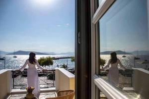 爱琴娜岛Naias Aegina, Sea-front apartment 95 sqm的两个女人站在一个阳台上望着水面