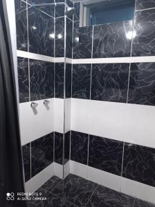 豪哈Casa Hospedaje VIRREY的浴室设有黑色和白色瓷砖和淋浴。