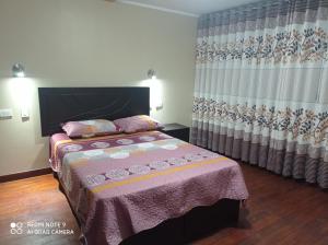 豪哈Casa Hospedaje VIRREY的一间卧室配有床和窗帘