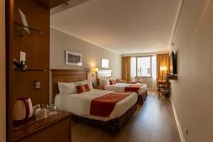 布宜诺斯艾利斯Blank Hotel Recoleta的酒店客房设有两张床和窗户。