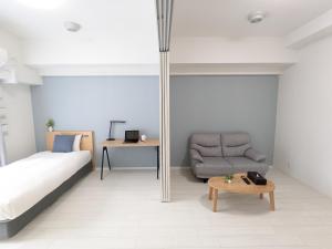 大阪ESLEAD HOTEL Namba Daikokucho的一间卧室配有一张床、一把椅子和一张桌子