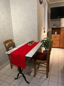 安纳马斯Le Clos du Chateau Rouge 3* avec Parking securisé的一张红色和白色的桌子、两把椅子和电视