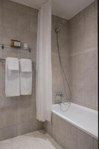 奥尔堡赫尔南凤凰酒店的浴室配有浴缸、淋浴和毛巾。