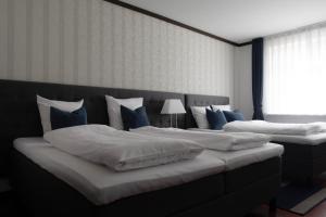 奥尔堡赫尔南凤凰酒店的配有两张床铺的蓝色和白色枕头