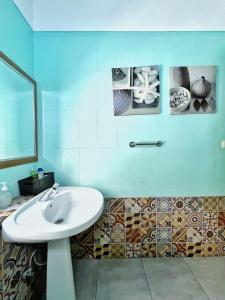 圣克鲁斯-德特内里费特内里费之旅旅馆的一间带水槽的浴室和墙上的一些图片