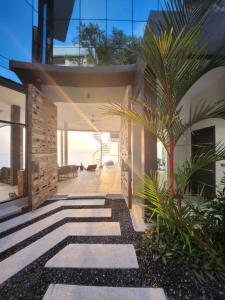 茶云莱海滩Villa Seawadee - luxurious, award-winning design Villa with amazing panoramic seaview的一条走道中间有棕榈树的房子