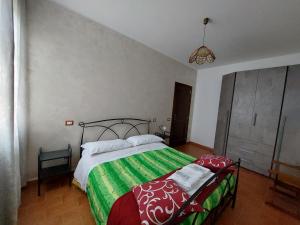 托迪伊尔法尔科农家乐的一间卧室配有一张带绿色和白色毯子的床