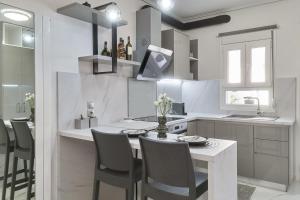 米蒂利尼Modern Studio for Two, Mytilene Lesvos的白色的厨房配有桌椅和柜台。