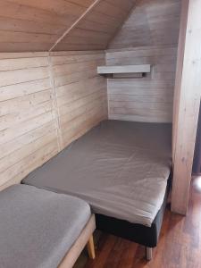 LusterKvamshaugen hytter的小型客房的一张床位,设有木墙