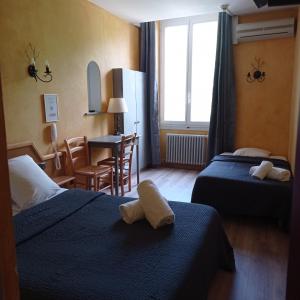奥朗日圣让酒店的酒店客房设有两张床和一张桌子。