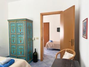 马里迪莫Rosa Dei Venti Marettimo的卧室配有蓝色和绿色的橱柜,位于床边