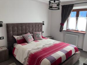 卡纳泽伊Dolomites Holiday Home的一间卧室配有一张大床,铺有红白毯子