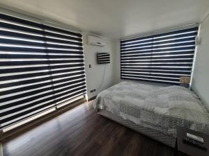 洛斯安第斯Apartamento Los Andes的一间卧室设有2个大窗户和1张床