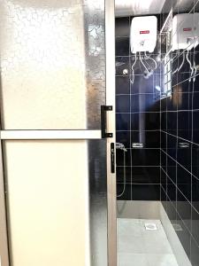 坎帕拉Elvina Home Buziga的浴室里设有玻璃门淋浴