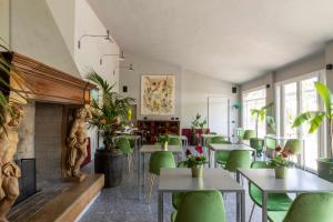 明乔河畔的瓦雷奇奥Relais Borghetto的一间设有绿色桌椅和壁炉的餐厅