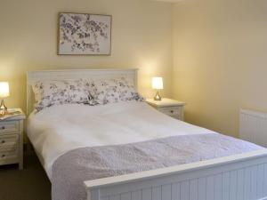 Barnby MoorCowslip - Uk13138的一间卧室配有一张带2个床头柜的大型白色床